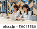 パソコンに向かって不満気に作業をする二人の若い女性 59043680