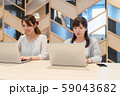 パソコンに向かって笑顔で作業をする二人の若い女性 59043682