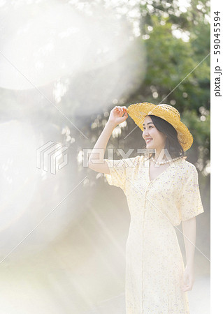 麦わら帽子で紫外線対策をして森林浴をする若い女性 59045594