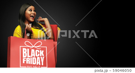 Young woman in dress shopping on black background 59046050