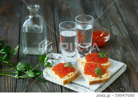 Vodka and traditional snack on wooden background Vodka and traditional snack on wooden background 59047080
