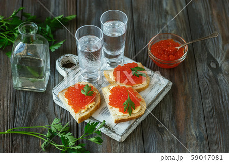 Vodka and traditional snack on wooden background 59047081