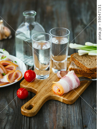 Vodka and traditional snack on wooden background Vodka and traditional snack on wooden background 59047131
