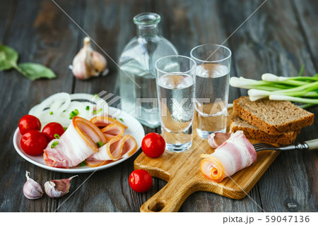 Vodka and traditional snack on wooden background 59047136