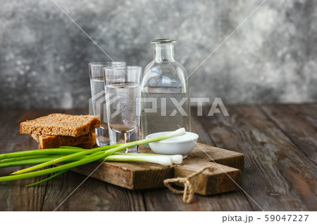 Vodka and traditional snack on wooden background Vodka and traditional snack on wooden background 59047227