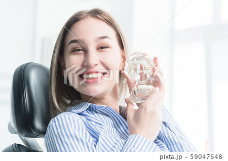 Portrait of a happy attractive girl in a dental chair. Laughing girl at the dentist's appointment Portrait of a happy attractive girl in a dental chair. Laughing girl at the dentist's appointment 59047648
