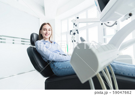 Portrait of an attractive smiling girl blonde in a dental chair. Happy customer dental cabinet 59047662