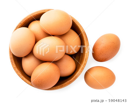 Chicken eggs in a wooden plate on a white. The Chicken eggs in a wooden plate on a white. The 59048143