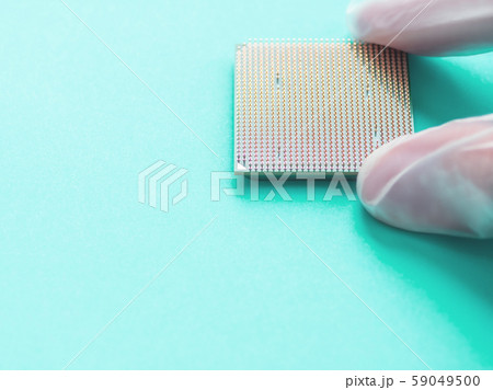 Hand in rubber glove with Central Computer Processor. CPU on neo mint background. Technological detail of personal computer. Hand in rubber glove with Central Computer Processor. CPU on neo mint background. Technological detail of personal computer. 59049500