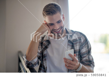 Cheerful bearded man reading message from girlfriend 59050841