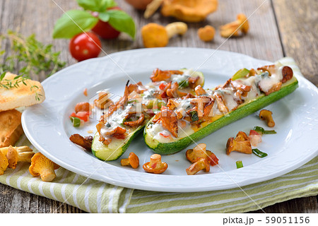 Zucchini halves stuffed with fresh chanterelles and topped with grated gorgonzola cheese 59051156