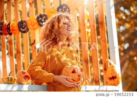 Halloween Preparaton Concept. Young woman standing outdoors with jack-o'-lantern smiling inspired 59052253