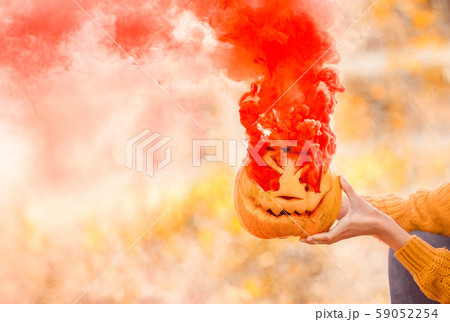Orange and ripe carved jack-o-lantern pumpkin with smoke 59052254