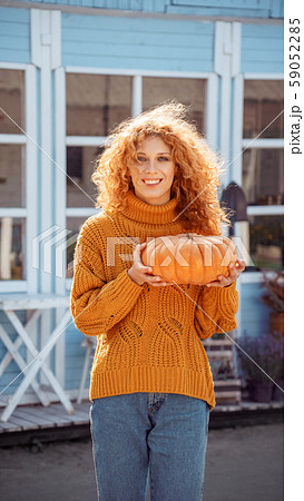 Woman holding ripe orange pumpkin in hands Woman holding ripe orange pumpkin in hands 59052285
