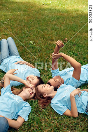 Volunteering. Young people volunteers outdoors lying resting laughing cheerful Volunteering. Young people volunteers outdoors lying resting laughing cheerful 59052325
