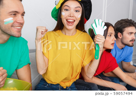 Group of friends sport fans watching match in colorful shirts girl looking camera close-up 59057494