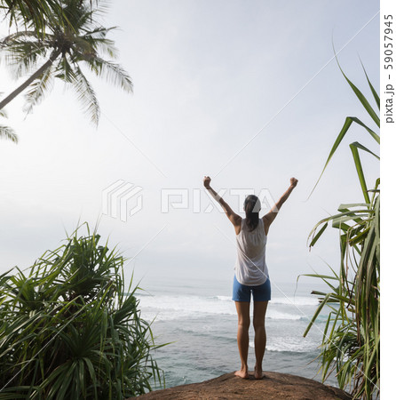 Freedom woman outstretched arms on seaside rock Freedom woman outstretched arms on seaside rock 59057945