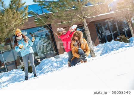 Winter vacation. Family time together outdoors playing snowballs cheerful Winter vacation. Family time together outdoors playing snowballs cheerful 59058549