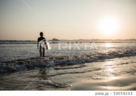 Female surfer with surfboard on the beach at 59059203