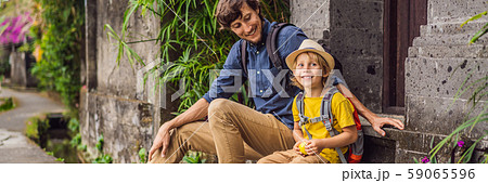 Father and son tourists in Bali walks along the narrow cozy streets of Ubud. Bali is a popular 59065596