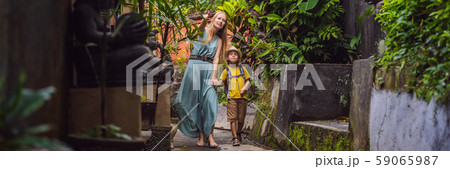 Mother and son tourists in Bali walks along the narrow cozy streets of Ubud. Bali is a popular 59065987
