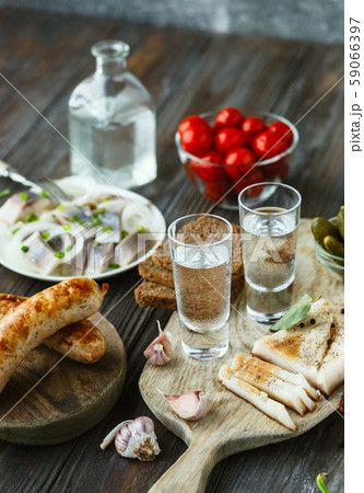 Vodka and traditional snack on wooden background Vodka and traditional snack on wooden background 59066397