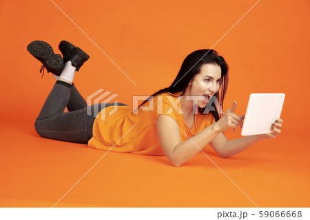 Caucasian young woman's portrait on orange background 59066668