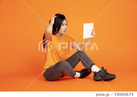 Caucasian young woman's portrait on orange background 59066674