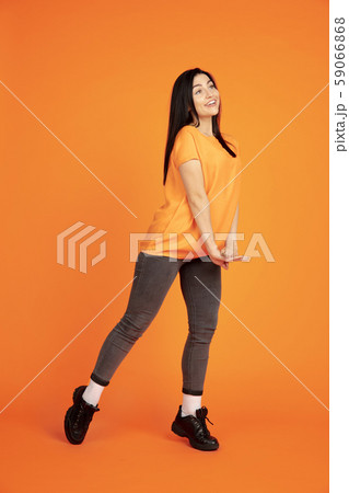 Caucasian young woman's portrait on orange background 59066868