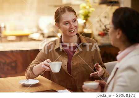 Friends drinking coffee in cafe Friends drinking coffee in cafe 59068173