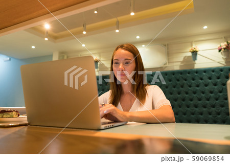Cute woman using a notebook in a cafe Cute woman using a notebook in a cafe 59069854