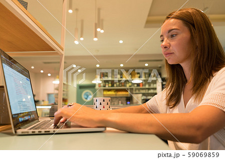 Cute woman using a notebook in a cafe Cute woman using a notebook in a cafe 59069859