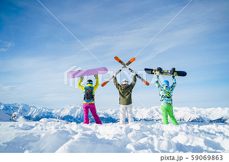 Photo from back of three snowboarders with their hands on snow resort Photo from back of three snowboarders with their hands on snow resort 59069863