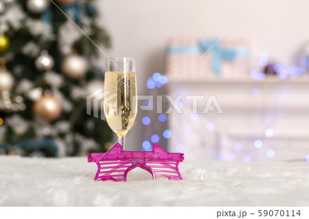 New Year. Decorated room no people glass of champagne and fancy glasses close-up blurred background New Year. Decorated room no people glass of champagne and fancy glasses close-up blurred background 59070114