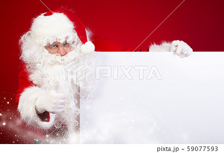 Santa Claus pointing in white blank sign with 59077593