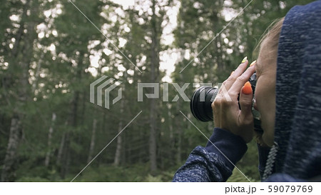 Traveler photographing scenic view in forest. One caucasian woman shooting close up look. Girl take 59079769