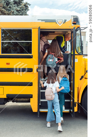 Classmates going up to school bus back view Classmates going up to school bus back view 59080066