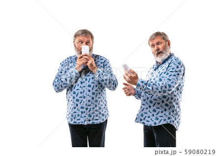 Senior man arguing with himself on white studio background. 59080219