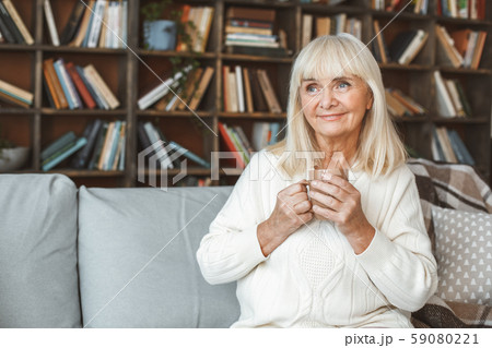 Senior woman at home retirement concept sitting drinking tea memories 59080221