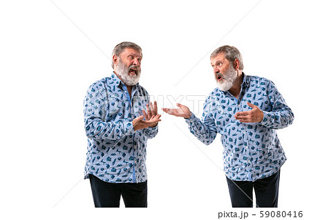 Senior man arguing with himself on white studio background. 59080416