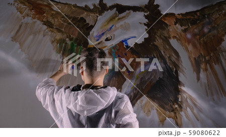 Artist designer draws an eagle on the wall. Craftsman decorator paints picture with acrylic oil 59080622