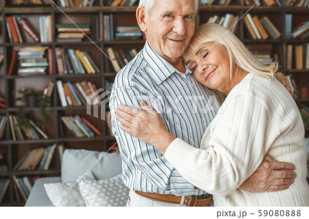 Senior couple together at home retirement concept standing head on shoulder 59080888