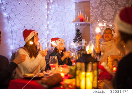 Beautiful young mother looking at her hand fireworks during christmas celebration with her family 59081474