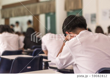 Blur school background back view university students writing answer doing exam in classroom Blur school background back view university students writing answer doing exam in classroom 59082812