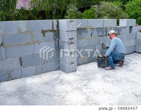 Bricklayer putting down another row of bricks in site 59083437