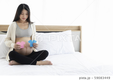 Pregnant Asian woman smiling and happy guessing baby boy or girl.. Baby gender prediction 59083449