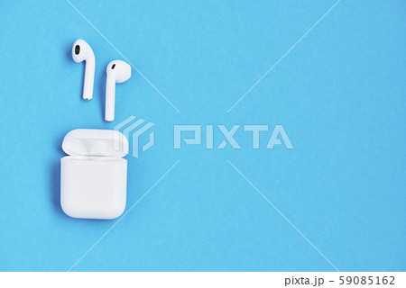 White wireless earphones on blue background. White wireless earphones on blue background. 59085162