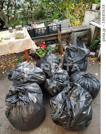 Black bags with trash on the street in the yard 59085639