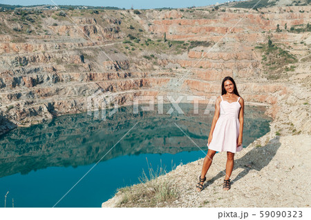 Beautiful woman with long hair in dress looks at the landscape of the lake 59090323