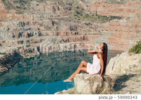 Beautiful woman with long hair in dress looks at the landscape of the lake 59090343